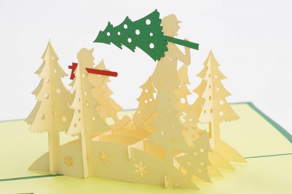 Christmas Card:Father and son walking through the forest with a fresh cut Christmas tree(inside close-up)
