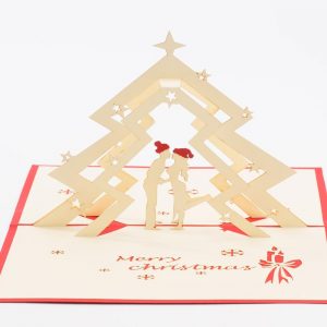Christmas pop up greeting cards: A 3D pop up scene with a couple kissing under a Christmas tree .