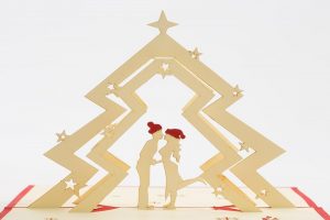 Christmas pop up greeting cards: A 3D pop up scene with a couple kissing under a Christmas tree.