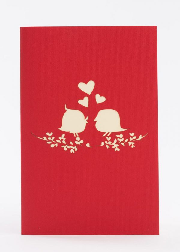 Love Birds holding wedding rings on a heart shaped flower. Front view