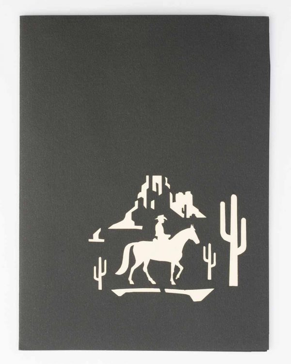 Front of card : Man on horse riding through the desert.